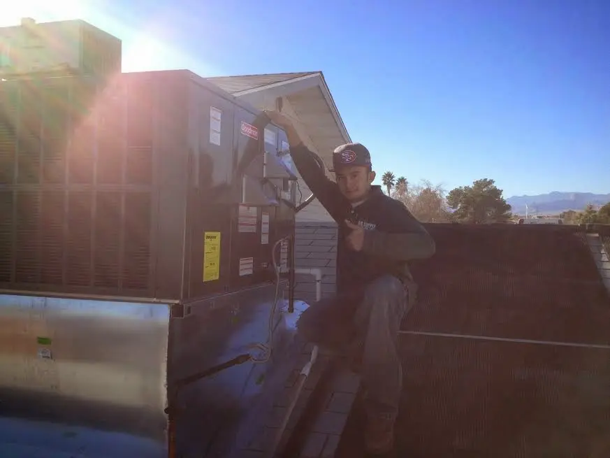 HVAC technician performing HVAC Inspection on a rooftop unit in Coweta